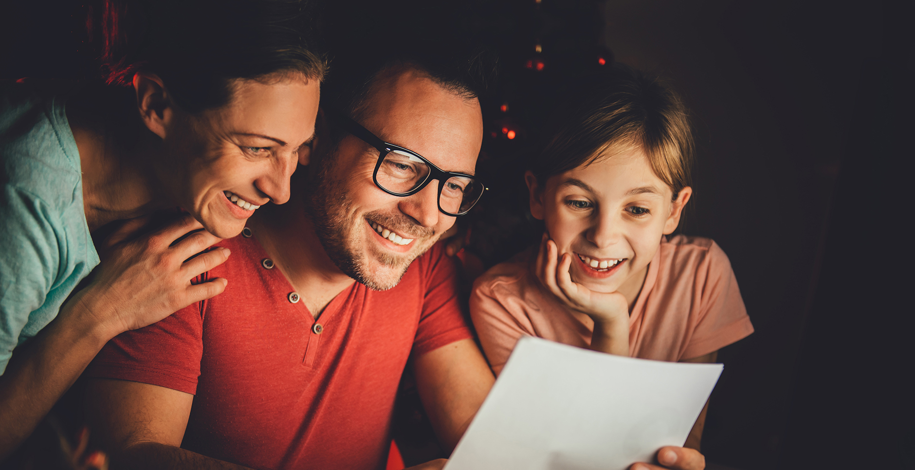 Father, mother and daughter reading letter late night
